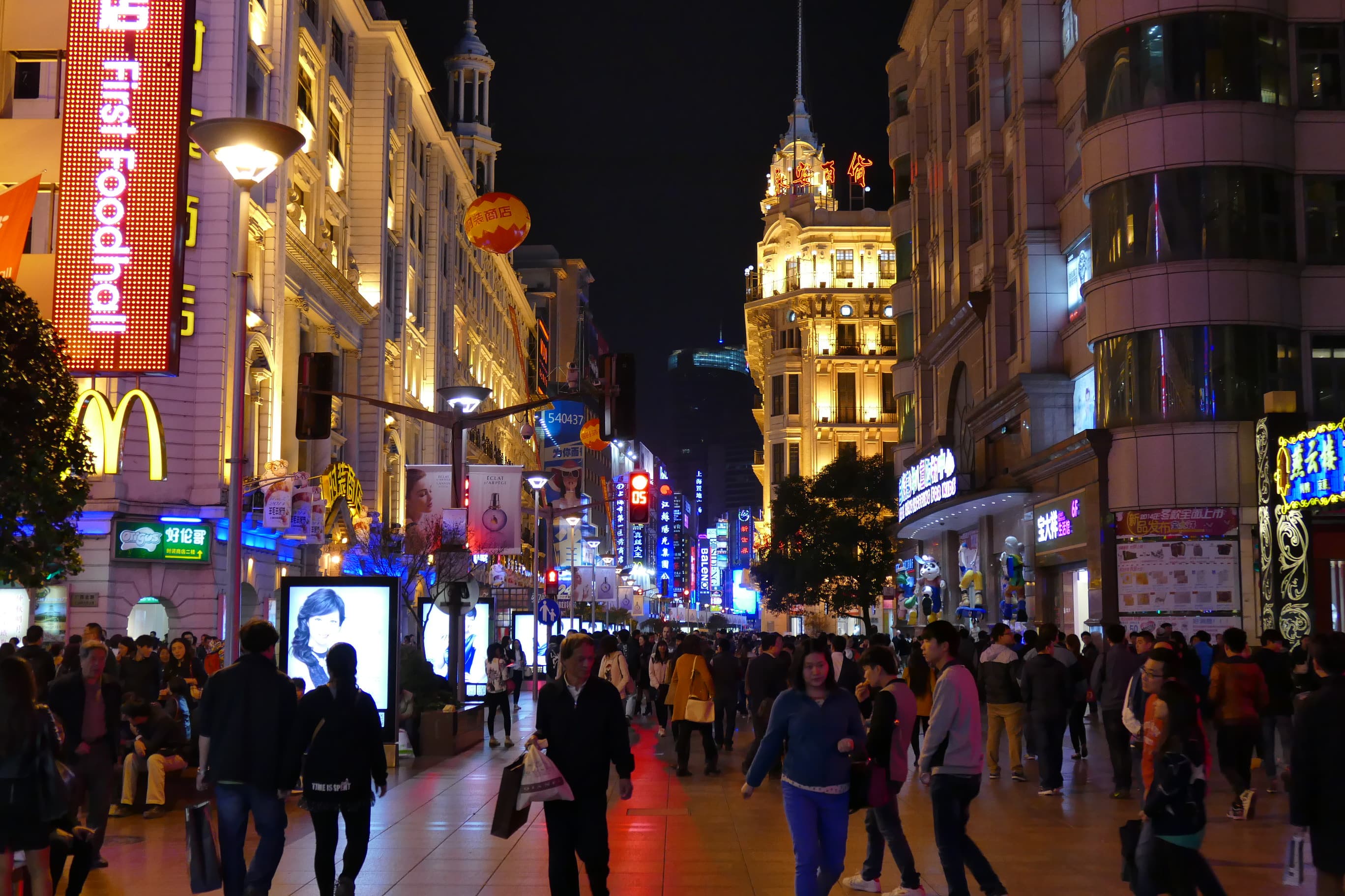 Pedestrians on Shanghai Nanjing Road at night in November 2014; historical location context