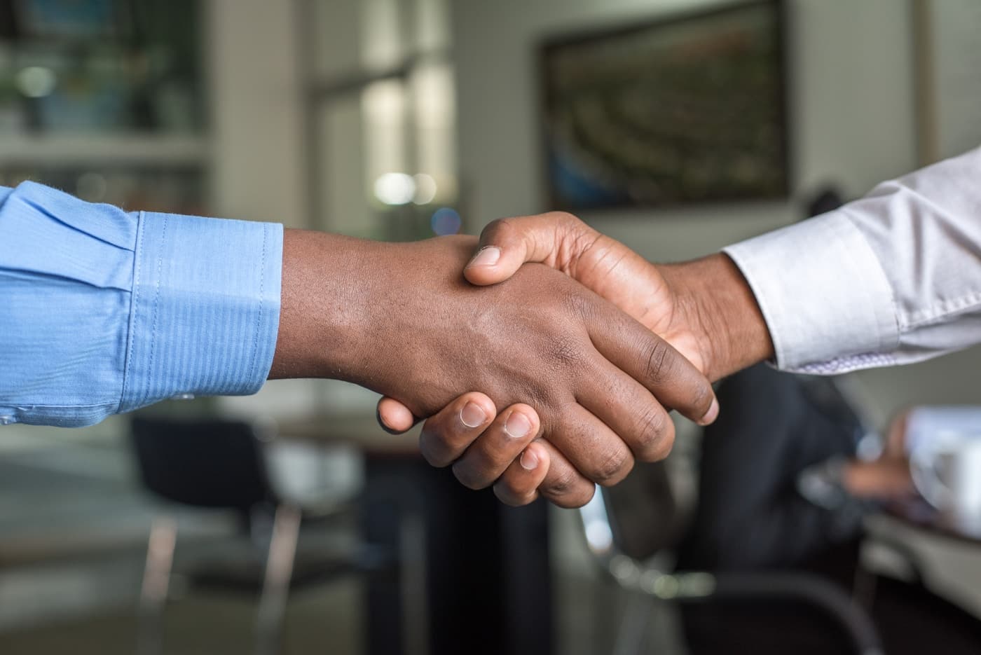 Illustrative photo of a diplomatic handshake in a meeting room.