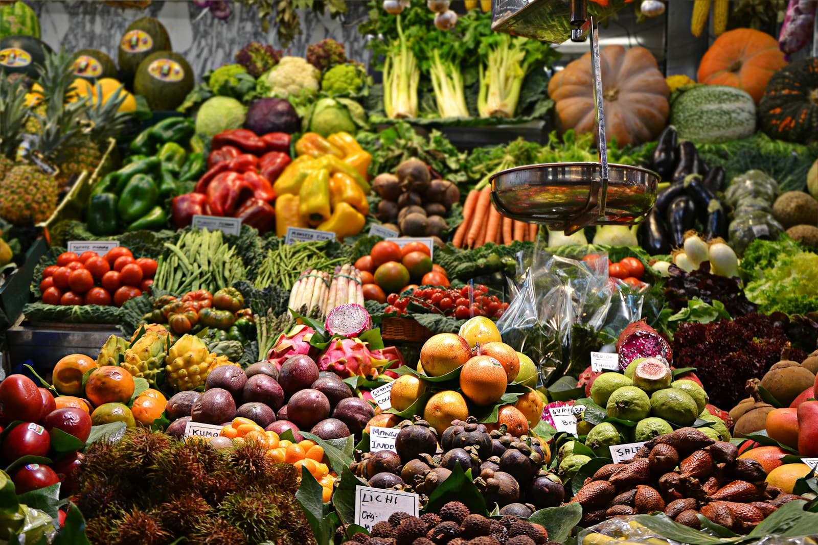 Shoppers move past fresh produce stalls in a public market.
