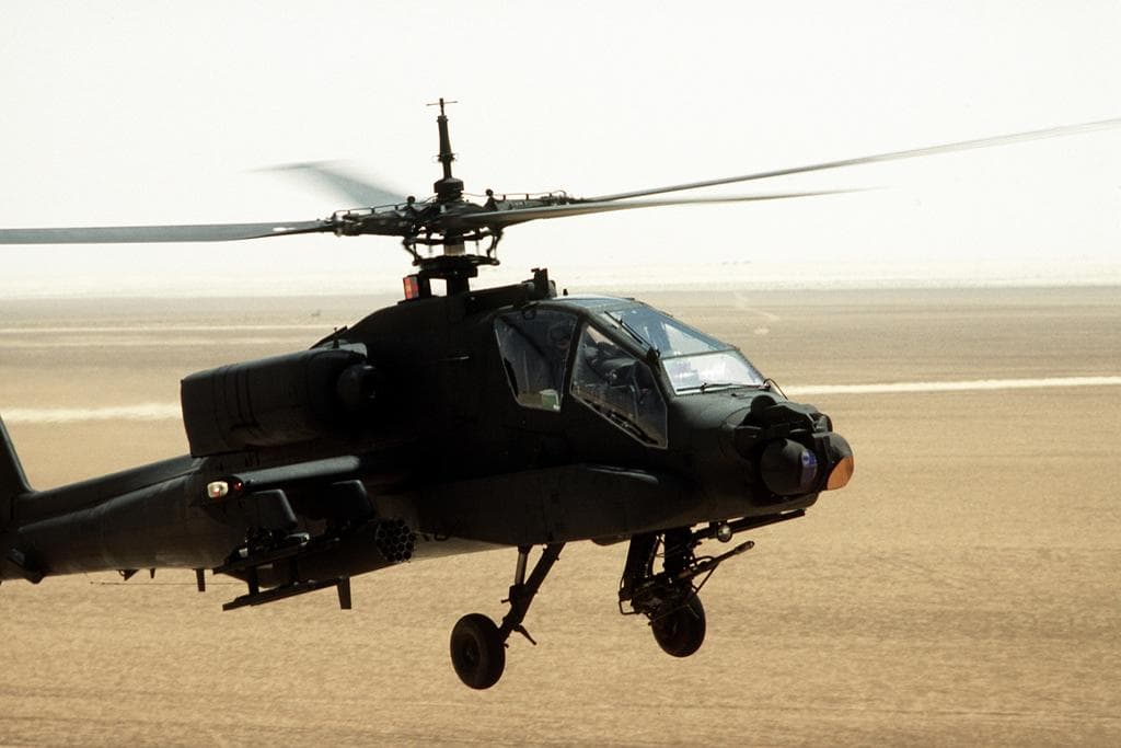 A U.S. Army AH-64 Apache helicopter in flight during Operation Desert Shield, used as context for a story about the downing of an Apache near the Strait of Hormuz.